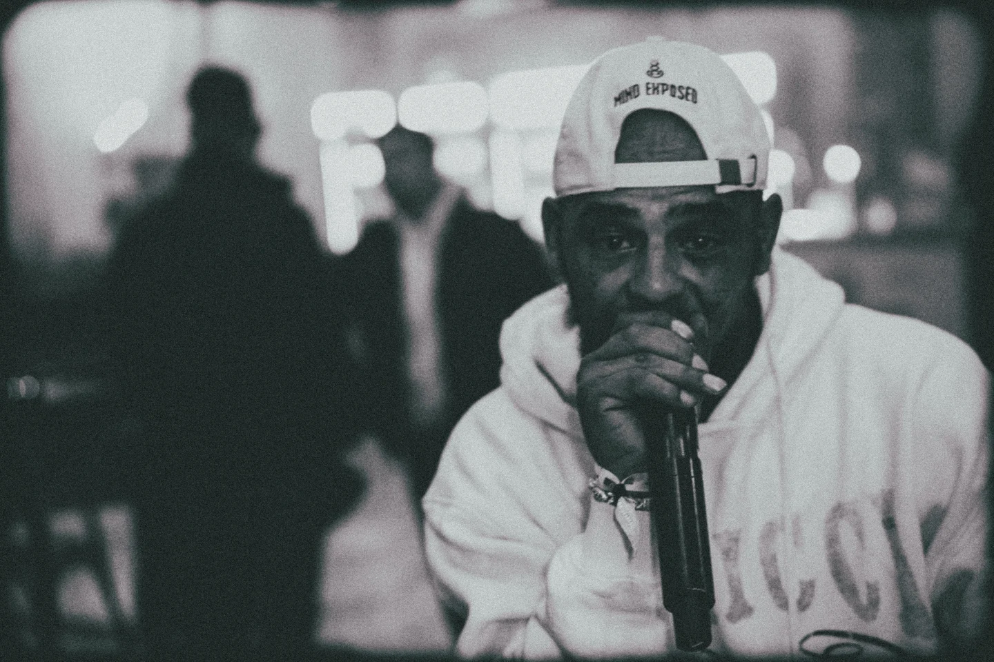 A rapper holds a microphone close at High Rollers, in black and white